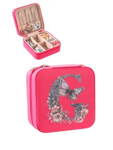 Detail of pink jewelry box with floral G initial and organized interior compartments