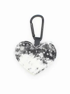 Detalle de llavero de mezclilla en forma de corazón con lentejuelas y clip.