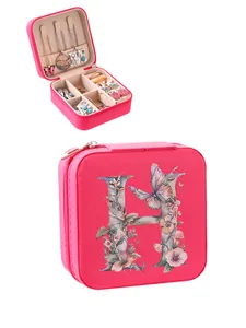 Detailed view of pink jewelry box with floral H initial and open compartments