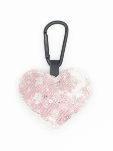 Detalle de llavero de corazón en denim rosa con lentejuelas y un clip metálico