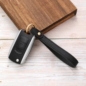 Minimalist black lychee grain leather keychain hand strap with gold hardware on car key
