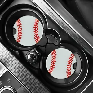 Close-up view of two baseball pattern car coasters inside a black vehicle cup holder.