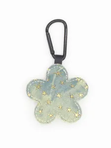Primer plano detallado de un llavero de flor de tela vaquera azul con lentejuelas de estrellas.