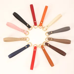 Diverse collection of colorful leather keychain wrist straps arranged in a circle.