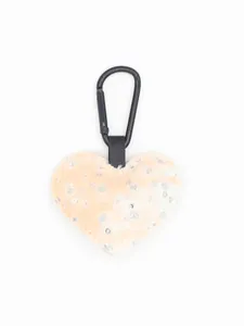 Primer plano de un llavero de corazón de mezclilla melocotón con lentejuelas y mosquetón