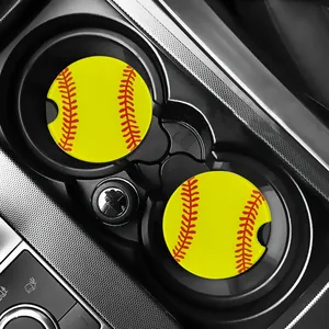 Vibrant yellow softball pattern car coasters set displayed in a car's cup holder.