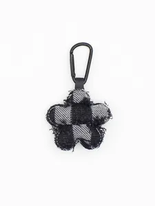 Detalle de un colgante para bolso con forma de flor de tela vaquera con mosquetón negro
