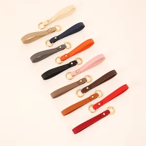 Detailed collection of solid color leather wristlet keychains with gold metal rings for bags