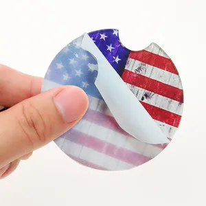 Detail view of acrylic car coaster with American flag design and protective film peeling