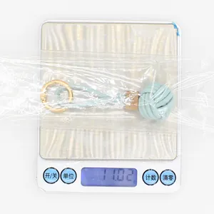 Detail showing 11.02g weight of light blue PU leather woven ball keychain pendant