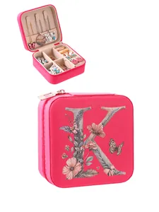 Compact pink jewelry travel case featuring floral initial K with multi-compartment interior