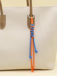 Nahaufnahme eines handgewebten Paracord-Taschenanhängers mit blau-orangefarbenem Design