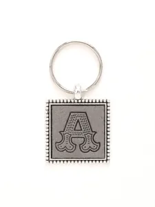 Detailed macro view of silver square zinc alloy keychain with embossed leather letter A