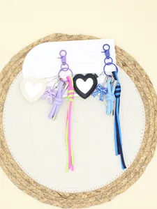 Detail view of colorful heart-shaped mirror keychains with handmade braided rope and bow
