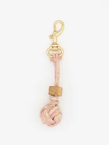 Close-up of handmade pink braided ball keychain with wooden bead and gold clasp