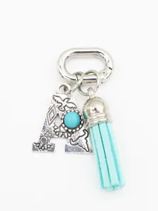 Detailed view of bohemian silver letter A keychain with turquoise and blue tassel