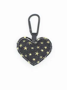 Detalle de llavero de mezclilla en forma de corazón con patrones de estrellas doradas.