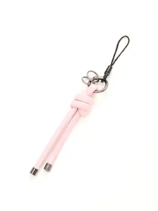 Close-up of pink handmade leather knot keychain with metallic rings detail.
