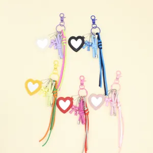 Detailed view of handmade woven heart mirror bag charms in vibrant colors