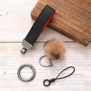 Detailansicht des Leder-Schlüsselanhänger-Sets mit Plüschbommel und Metallringen