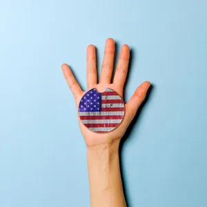American flag car coaster for cup holders held in hand on blue background