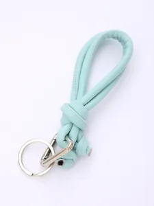 Detailed macro view of a hand-woven mint green PU leather lanyard with silver keychain
