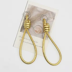 Elegant gold braided PU leather loop charms with silver metal rings on white background