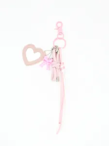Detailed view of a pink heart-shaped leather mirror charm with bow and braided cords