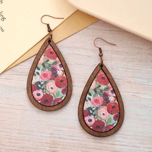 Detailed macro view of Bohemian teardrop wooden earrings with vintage floral patterns.