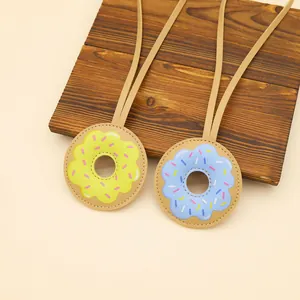 Macro view of cute donut-shaped PU leather bag charms with colorful icing prints