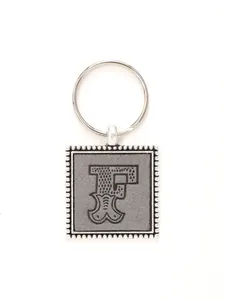 Close-up of personalized zinc alloy keychain with embossed leather letter F detail.