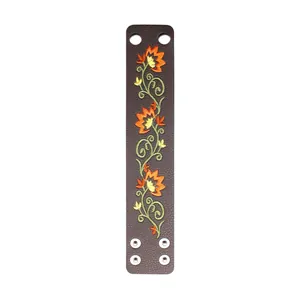Detailed flat view of a brown ethnic PU leather cuff with orange floral embroidery