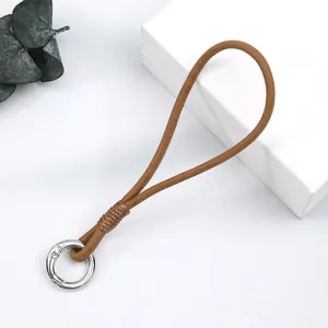 Detail view of handmade brown leather phone wrist strap with silver spring ring clasp