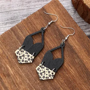Detail of bohemian geometric earrings with black wood and leopard print cork textures