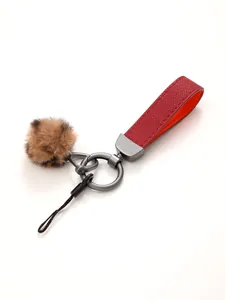 Detailansicht eines roten Schlüsselanhängers aus Leder mit Leoparden-Bommel-Anhänger