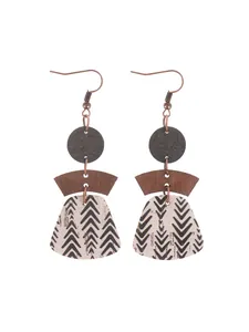 Macro detail of bohemian multi-layered geometric earrings featuring cork and wood texture