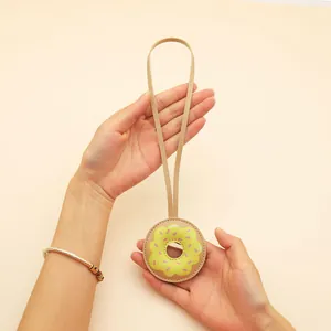 Close-up of cute cartoon PU leather donut keychain bag charm with long carrying strap
