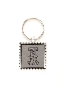 Macro detail of decorative embossed leather letter I keychain with zinc alloy beaded frame.