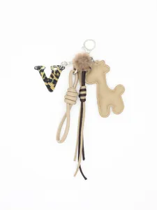 Dettaglio charm borsa con lettera V in acrilico leopardato e giraffa in pelle PU