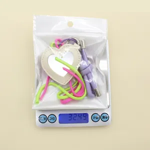 Heart-shaped leather mirror keychain weight measurement of 32.49g displayed on a digital scale