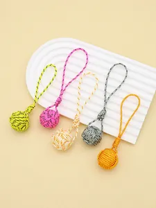 Handmade polyester monkey fist knot keychains in five vibrant colors displayed on a white stand.