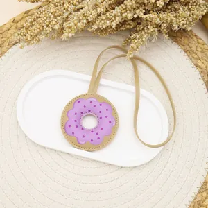 Macro view of cute purple donut bag charm made of premium PU leather for handbags
