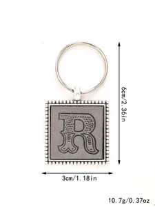 Close-up detail of embossed letter R leather keychain with dimensions and weight info