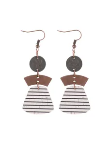 Close-up of bohemian layered geometric earrings with striped cork and wood elements