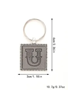 Detailed view of square leather keychain with embossed letter U and dimensions