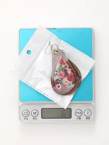 Detailed view of Bohemian wooden teardrop earrings on a digital scale weighing 6.1g