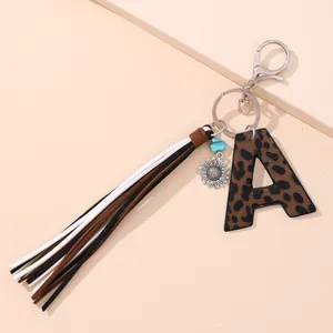 Detailed view of western leopard print leather letter A keychain with suede tassel charms
