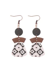 Detail of Bohemian multi-layer geometric earrings with black pattern on natural cork