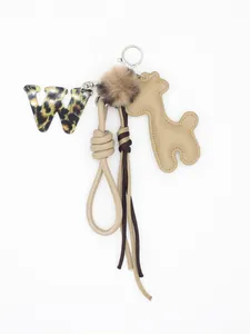 Dettaglio di un portachiavi con lettera W leopardata e grazioso ciondolo giraffa in PU