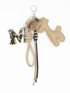 Dettaglio della lettera M in acrilico leopardato e ciondolo a giraffa in pelle PU